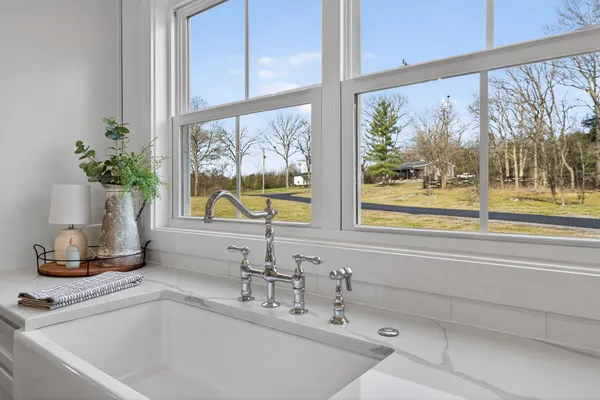 a bathroom with a sink and a large mirror next to a window
