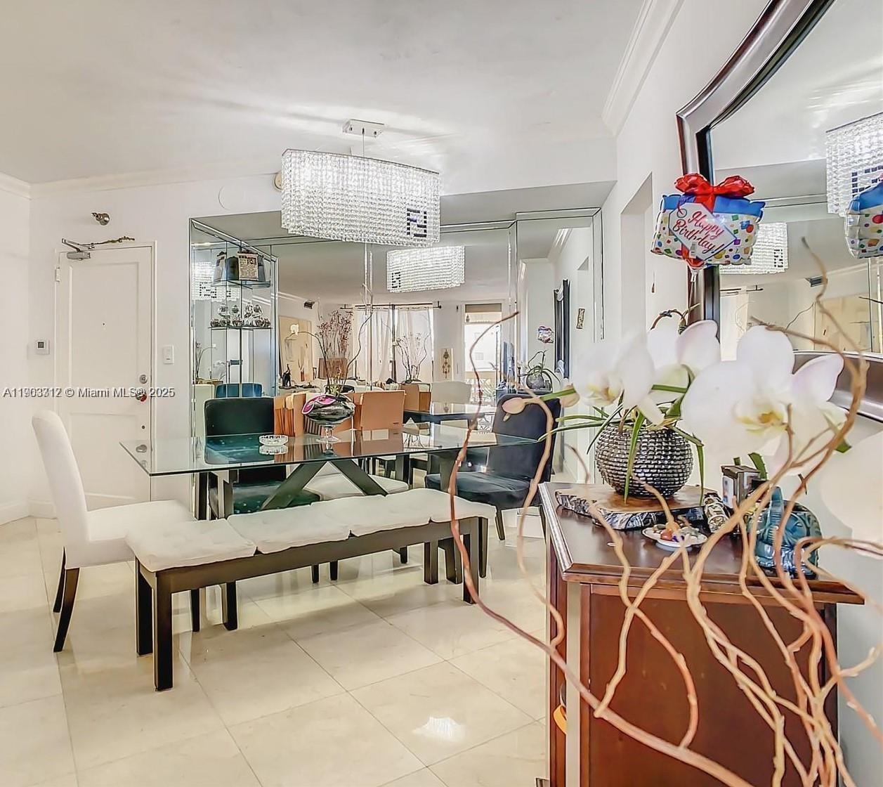 10185 Collins Avenue, Unit 308 Bal Harbour, FL 33154 - Photo 17 of 25 a living room with furniture and a chandelier