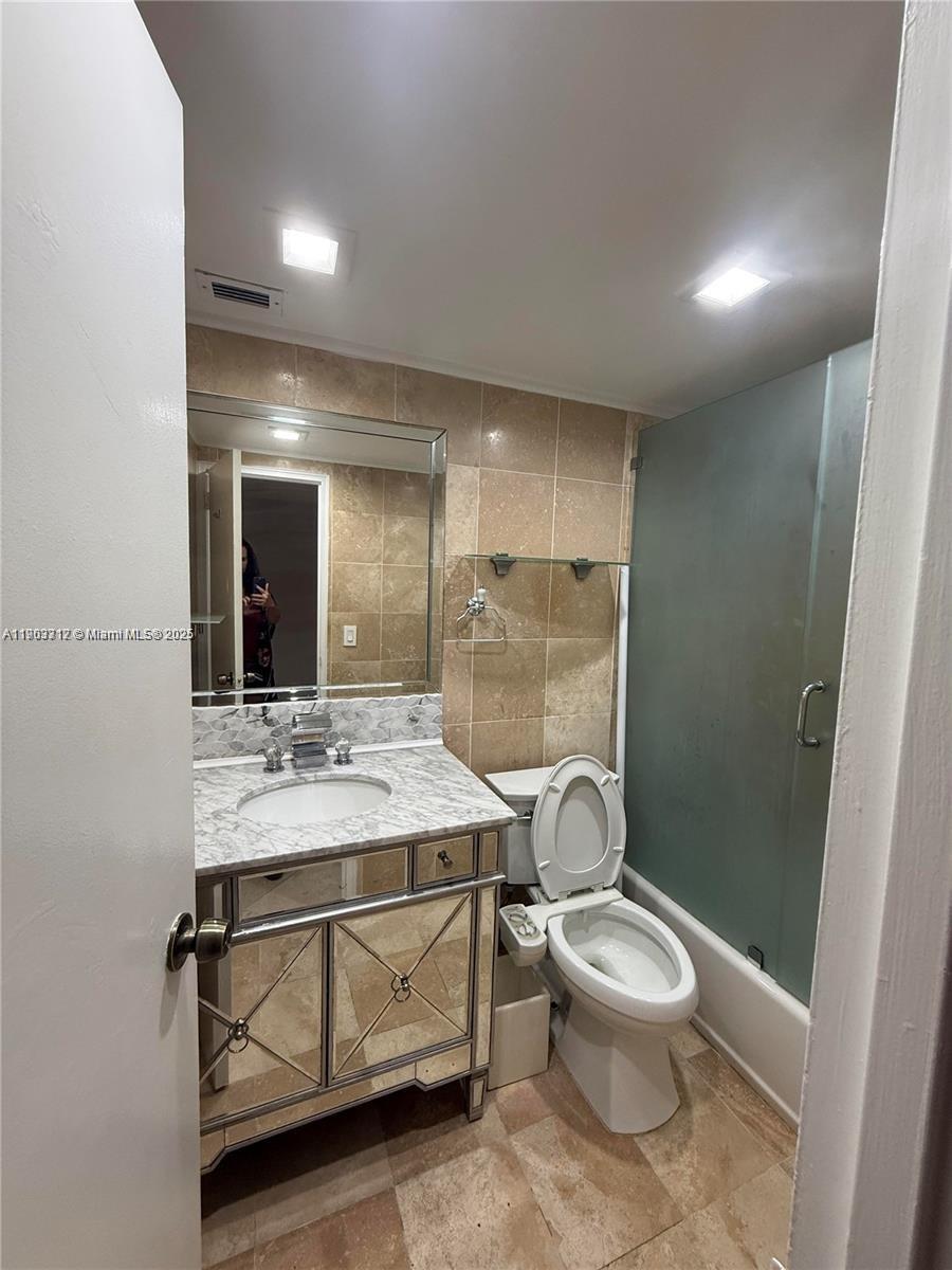 10185 Collins Avenue, Unit 308 Bal Harbour, FL 33154 - Photo 20 of 25 a bathroom with a sink toilet a mirror and vanity