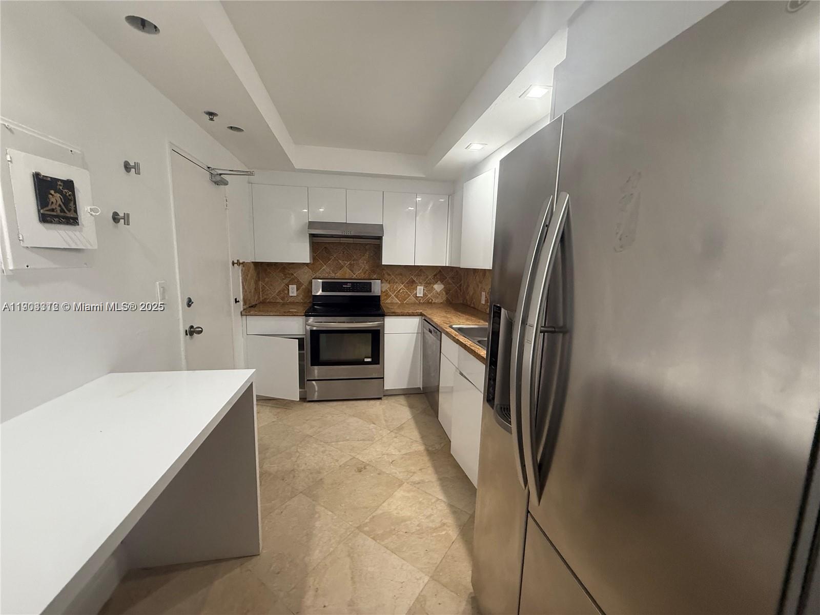 10185 Collins Avenue, Unit 308 Bal Harbour, FL 33154 - Photo 21 of 25 a kitchen with stainless steel appliances a refrigerator sink and microwave