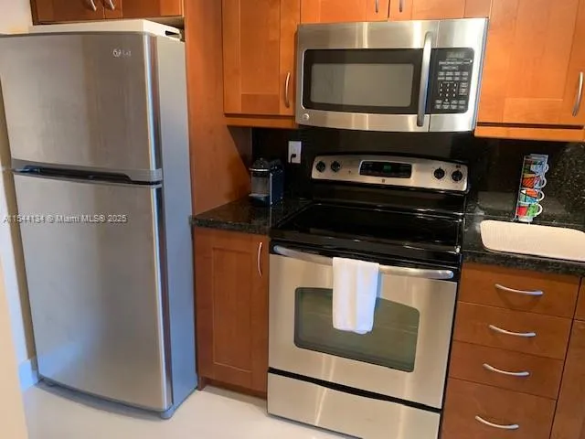 a kitchen with stainless steel appliances granite countertop a stove and a microwave