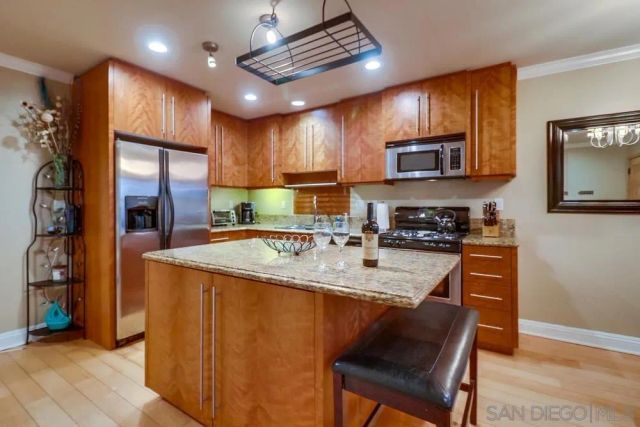 a kitchen with stainless steel appliances granite countertop a stove refrigerator sink and microwave