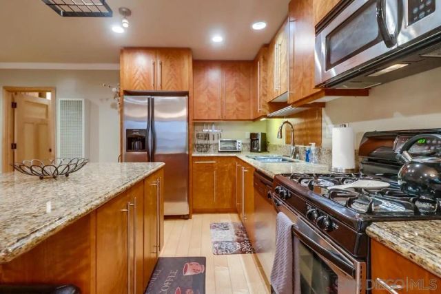 a kitchen with stainless steel appliances granite countertop sink stove and cabinets