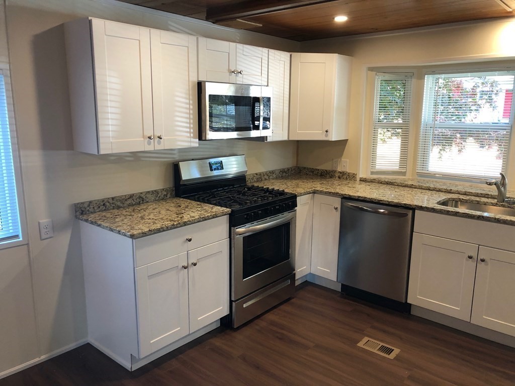 8 Lisa Circle Merrimac, MA 01860 - Photo 7 of 17 a kitchen with granite countertop a stove a sink and a microwave