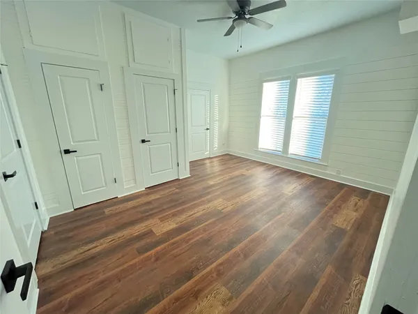 a view of a room with wooden floor and fan