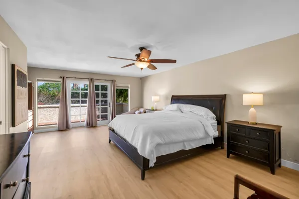 a spacious bedroom with a large bed and a chandelier
