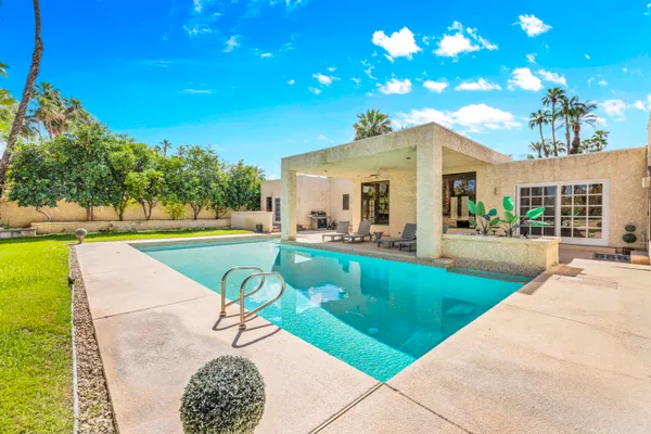 a view of an house with swimming pool and sitting area