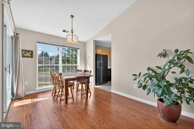 a dining room with furniture potted plants and wooden floor