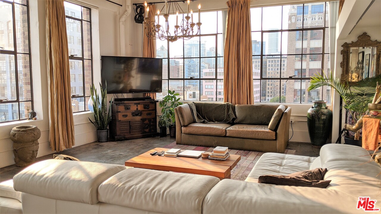 a living room with furniture a flat screen tv and a large window