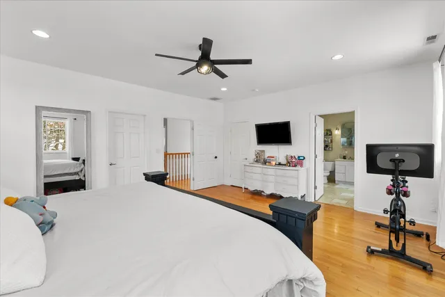 a bedroom with a bed a flat screen tv and couches