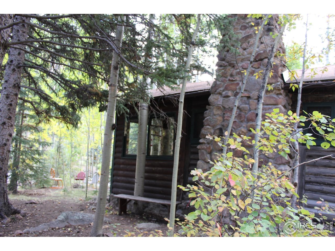 223 Riverside Drive Lyons, CO 80540 - Photo 28 of 33 West cabin side with stone chimney and looking at creek