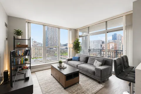 a living room with furniture and a floor to ceiling window
