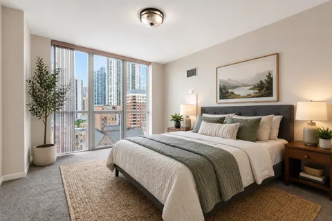 a spacious bedroom with a large bed and a potted plant