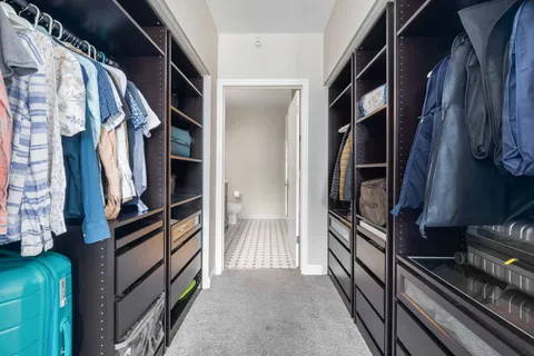 a view of walk in closet with clothes and shoes