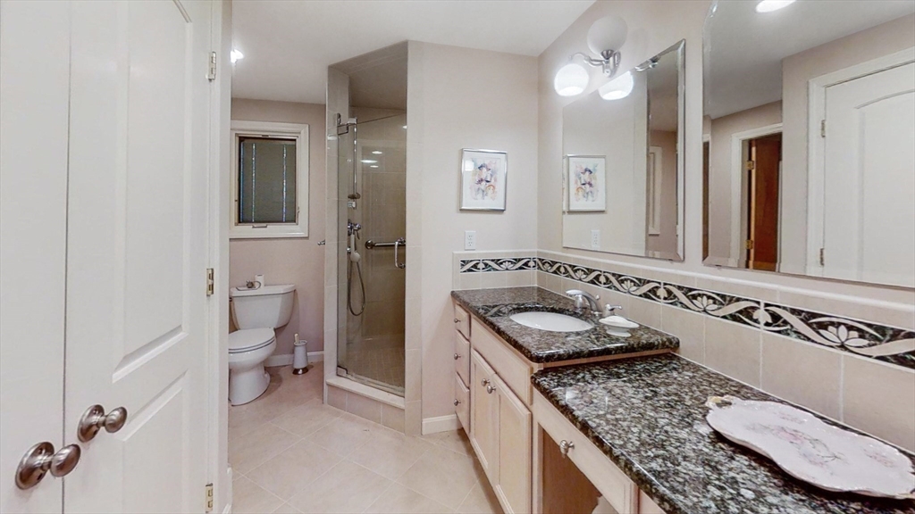 30 Tyler Road Lexington, MA 02420 - Photo 19 of 40 a bathroom with a granite countertop sink a toilet a mirror and shower