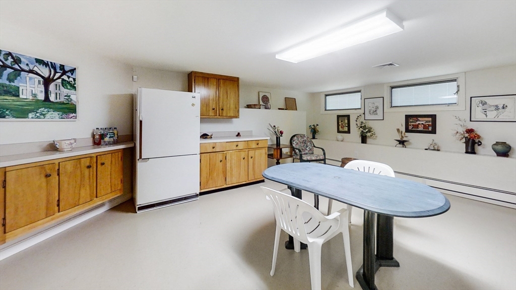 30 Tyler Road Lexington, MA 02420 - Photo 30 of 40 a kitchen with stainless steel appliances kitchen island a table chairs refrigerator and sink