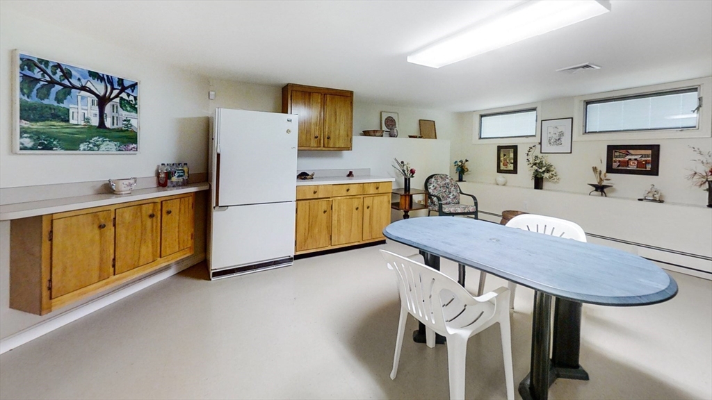 30 Tyler Road Lexington, MA 02420 - Photo 35 of 40 a kitchen with stainless steel appliances granite countertop a kitchen island a stove a sink a dining table and chair with wooden floor