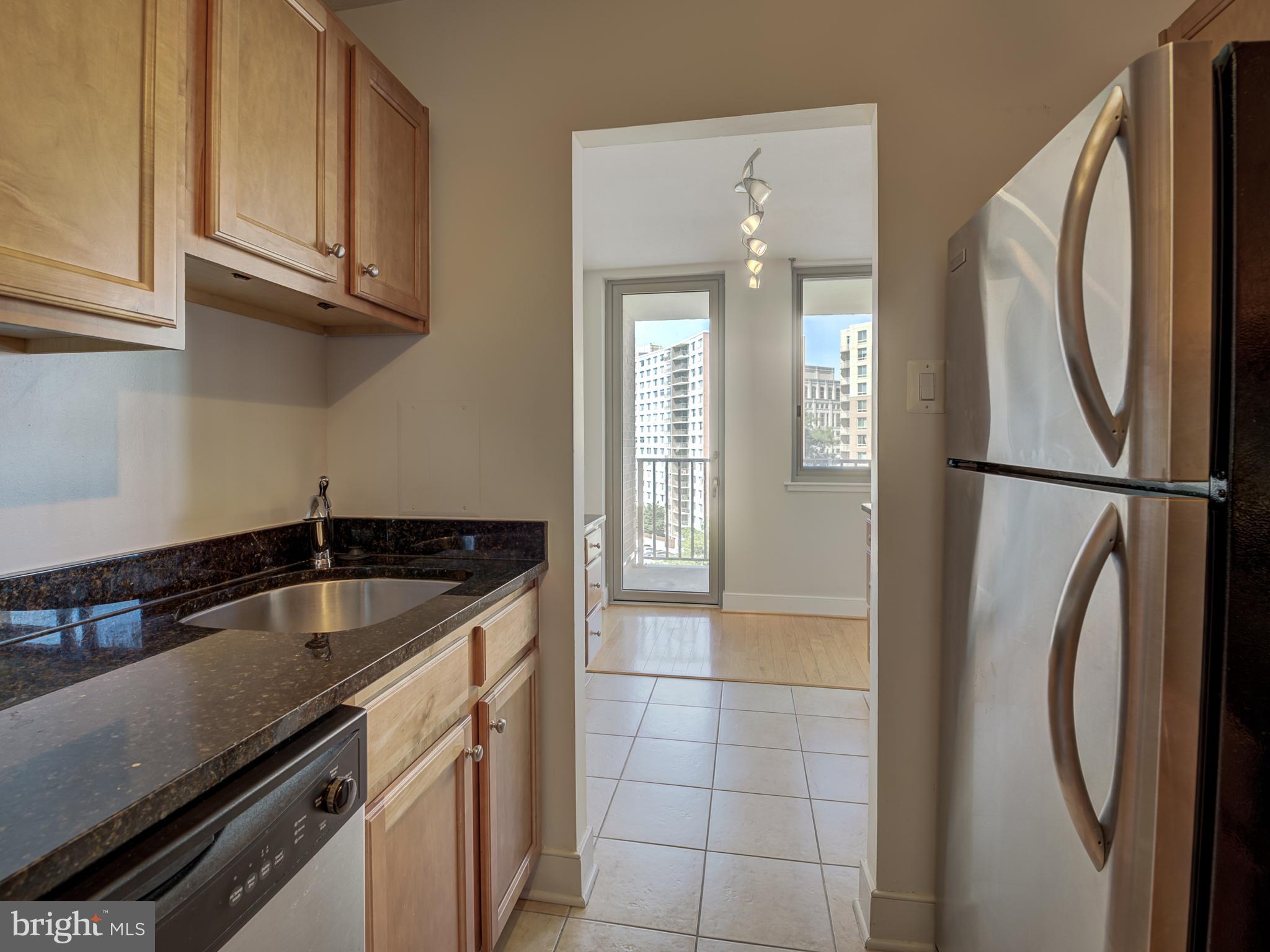 1220 Blair Mill Road, Unit 902 Silver Spring, MD 20910 - Photo 19 of 48 a kitchen with granite countertop a sink and a refrigerator