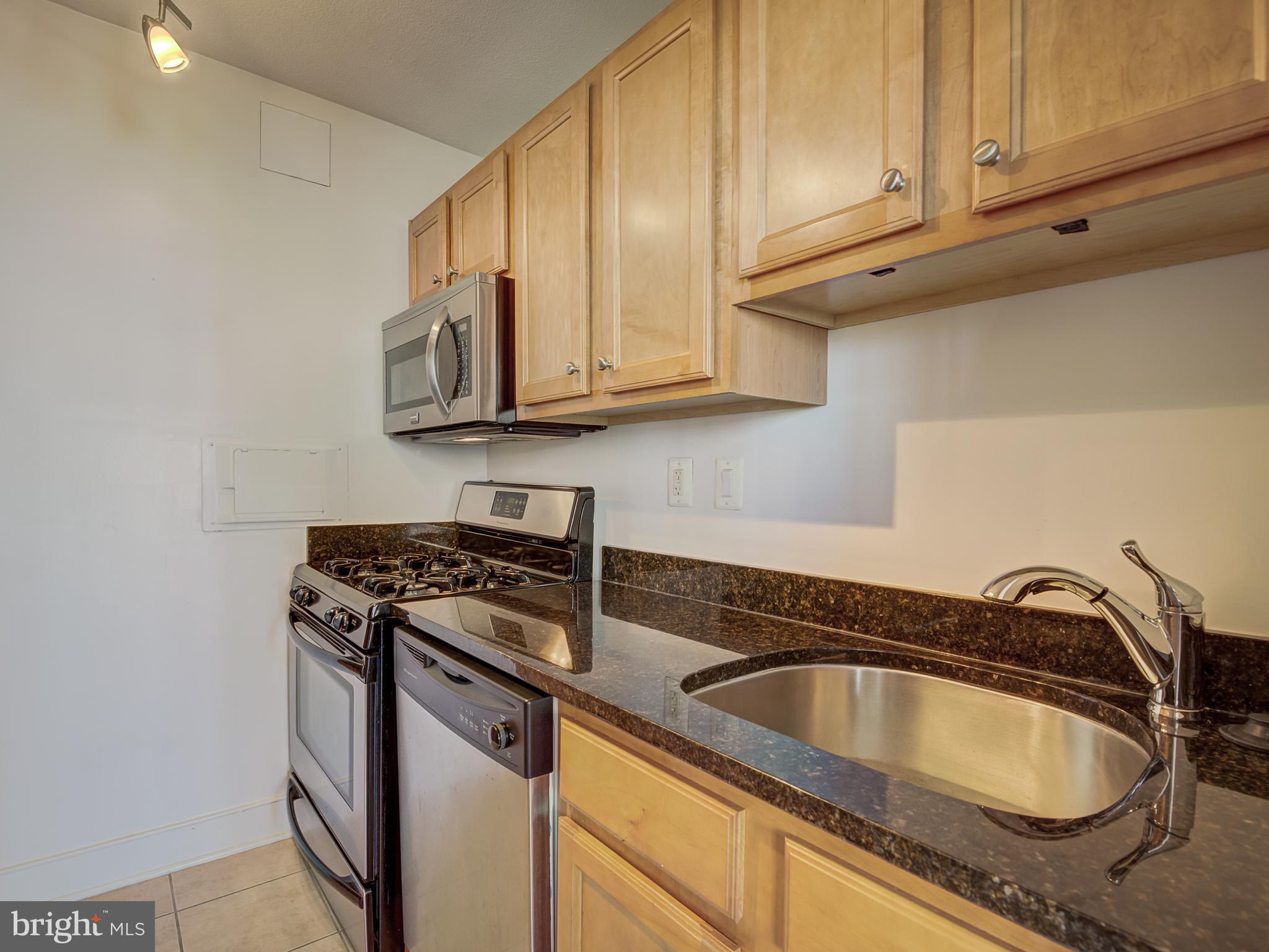 1220 Blair Mill Road, Unit 902 Silver Spring, MD 20910 - Photo 20 of 48 a kitchen with granite countertop a sink stove and cabinets