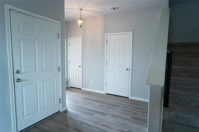 a view of empty room with wooden floor
