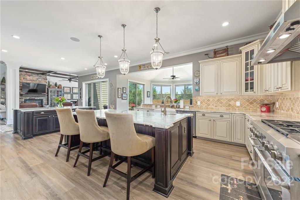 4040 Flowering Peach Road Marvin, NC 28173 - Photo 37 of 38 a kitchen with stainless steel appliances granite countertop a kitchen island a stove a table and chairs in it