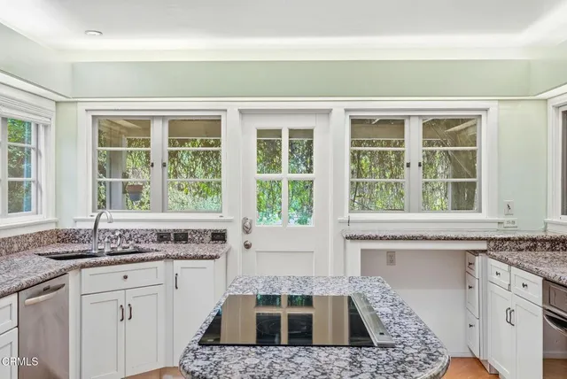 a kitchen with granite countertop a sink and cabinets