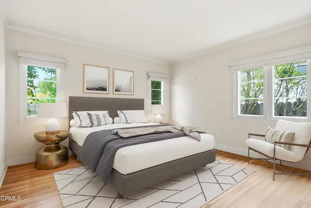 a view of an empty room with wooden floor and a bathroom