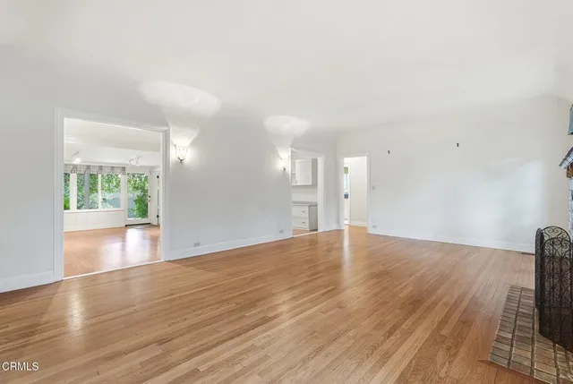 a view of empty room with wooden floor and fireplace