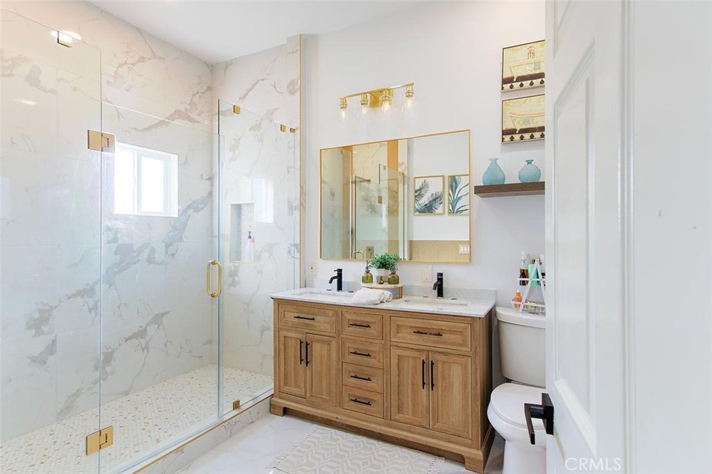 11523 Richeon Avenue Downey, CA 90241 - Photo 17 of 25 a bathroom with a double vanity sink a mirror a bathtub and shower