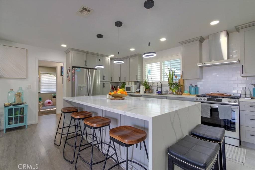 11523 Richeon Avenue Downey, CA 90241 - Photo 7 of 25 a kitchen with stainless steel appliances granite countertop a table chairs sink and stove top oven