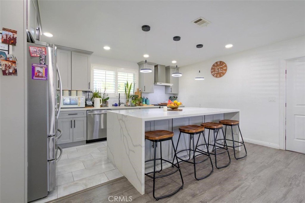 11523 Richeon Avenue Downey, CA 90241 - Photo 8 of 25 a kitchen with stainless steel appliances a table chairs and a refrigerator