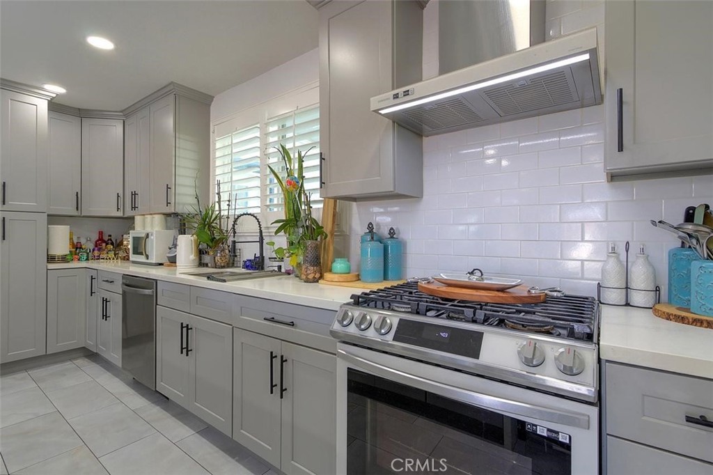 11523 Richeon Avenue Downey, CA 90241 - Photo 9 of 25 a kitchen with a stove and white cabinets