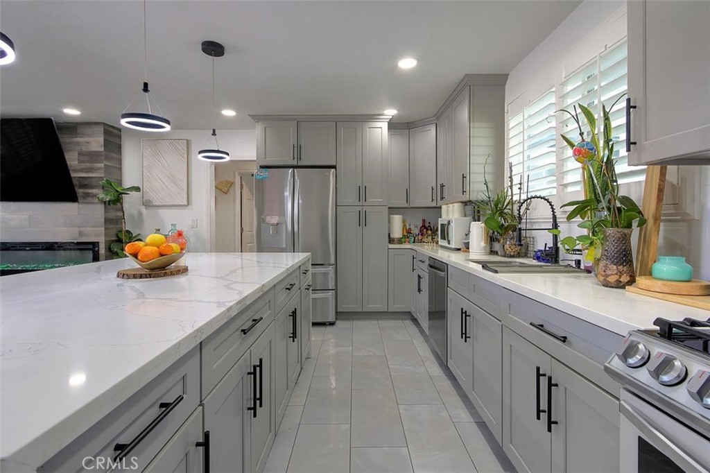 11523 Richeon Avenue Downey, CA 90241 - Photo 10 of 25 a kitchen with stainless steel appliances a sink a stove a refrigerator and cabinets