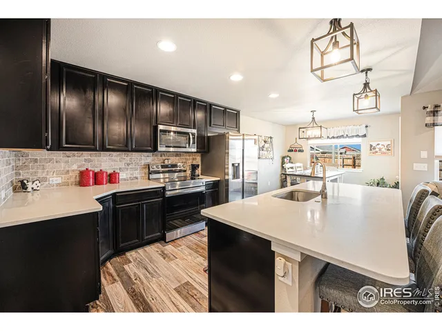 a kitchen with kitchen island granite countertop a sink cabinets and stainless steel appliances