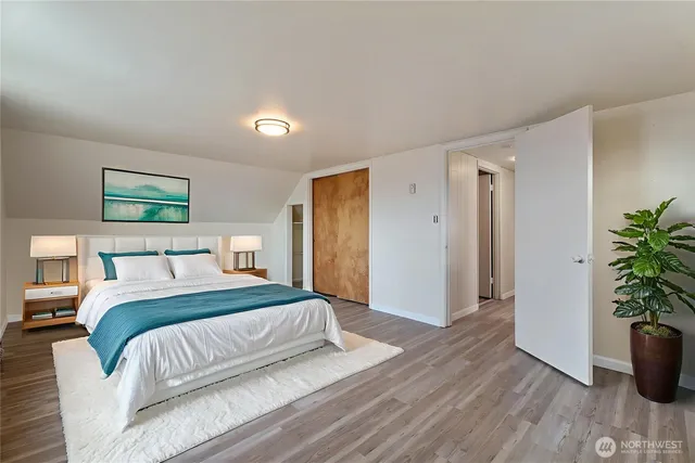 a spacious bedroom with a bed and a potted plant