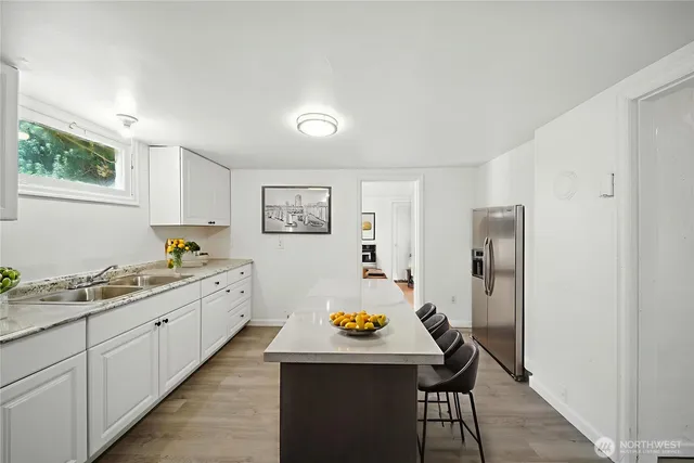 a kitchen with stainless steel appliances wooden floor and window