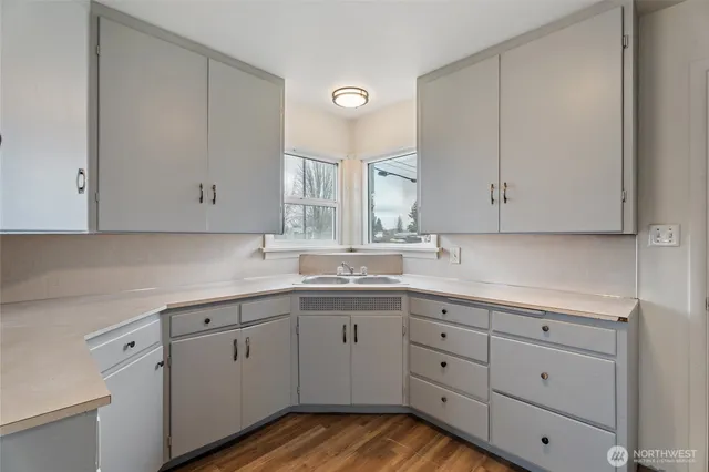 a kitchen with white cabinets and sink