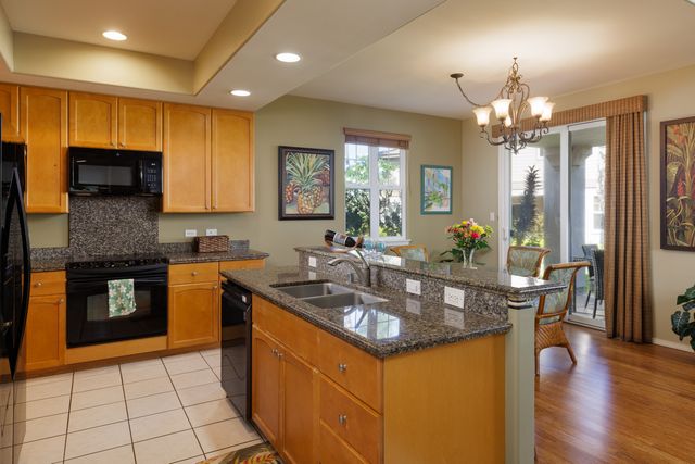 a kitchen with granite countertop a sink a counter top space appliances and cabinets