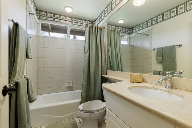 a bathroom with a granite countertop sink a toilet and shower