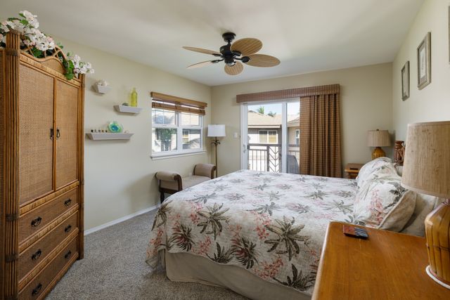 a bedroom with a bed and a dresser next to a window