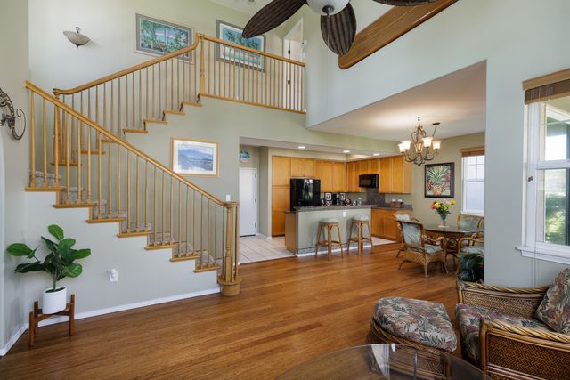 a living room with wooden floor and a potted plant