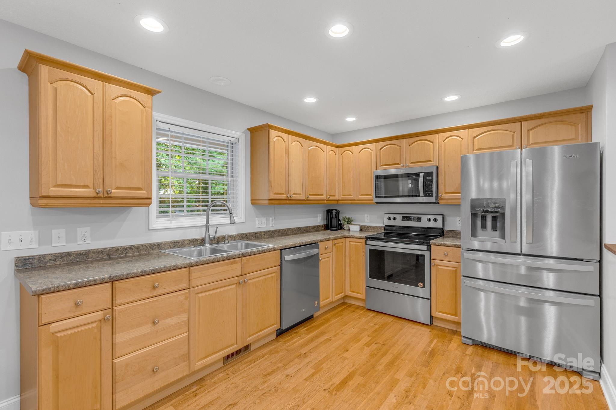 904 Mills Gap Road Fletcher, NC 28732 - Photo 11 of 36 a kitchen with stainless steel appliances granite countertop a stove a sink dishwasher a refrigerator and a microwave oven with wooden floor