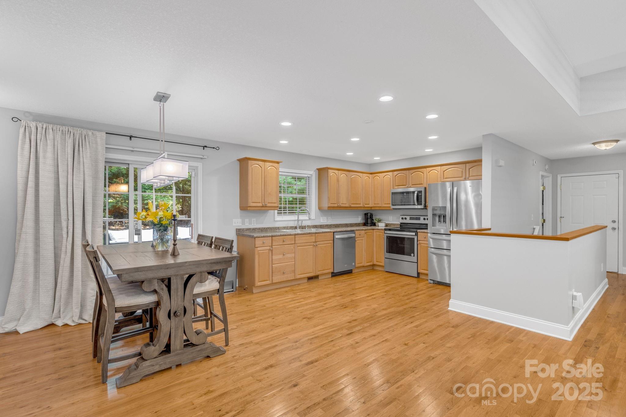 904 Mills Gap Road Fletcher, NC 28732 - Photo 9 of 36 a kitchen with a table chairs wooden floors and a view of living room