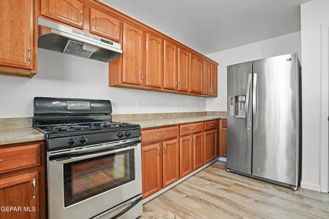 a kitchen with stainless steel appliances granite countertop a stove microwave and refrigerator