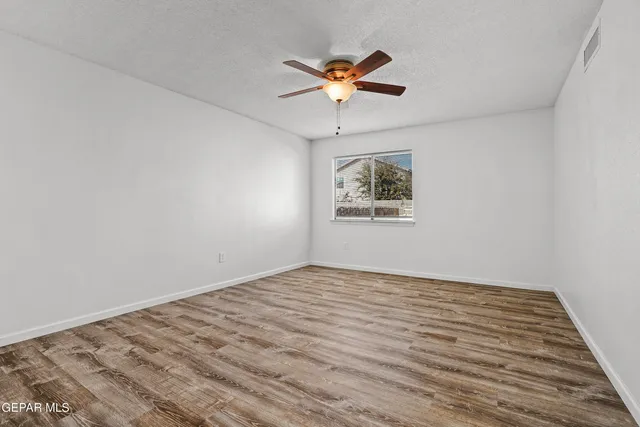 a view of empty room with wooden floor