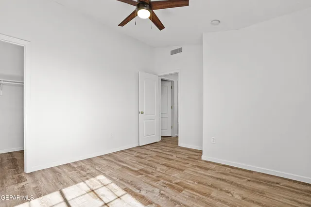 a view of a room with wooden floor and white walls