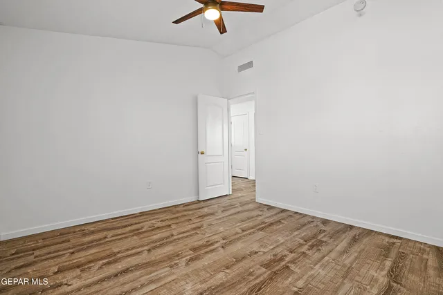 an empty room with a ceiling fan and carpet