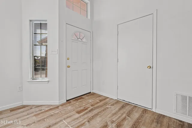 a view of an empty room with closet and a window