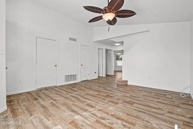 a view of empty room with wooden floor