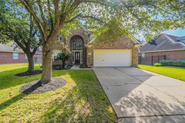 a front view of a house with yard and tree